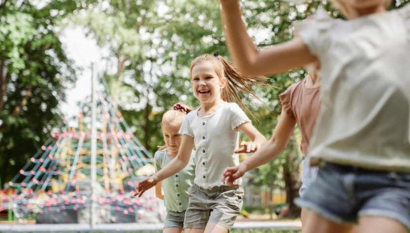 Group of kids playing at the playground in summer day