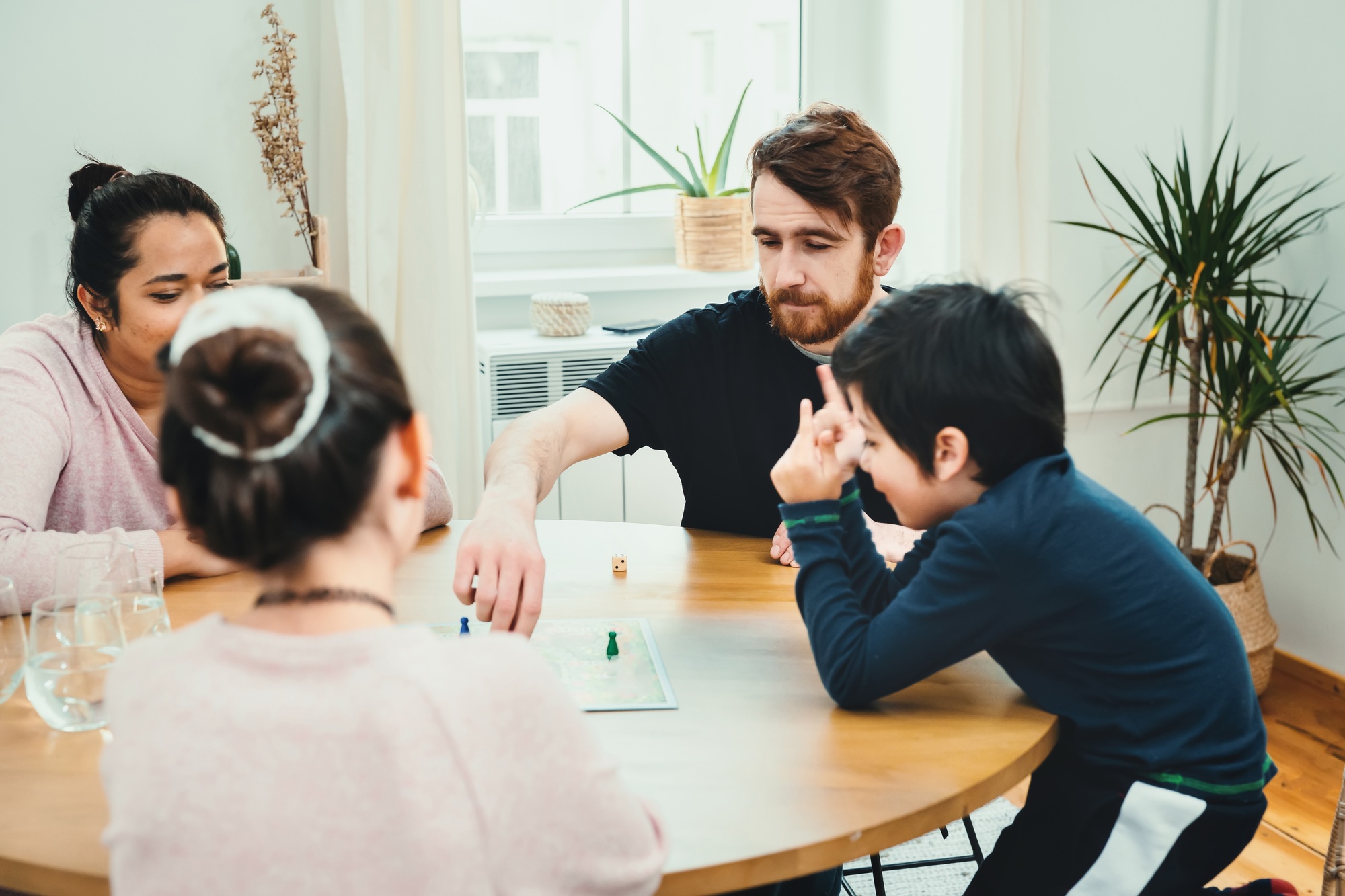 Mixed family playing with board game together at the table