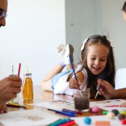 Mom and dad drawing with their daughter
