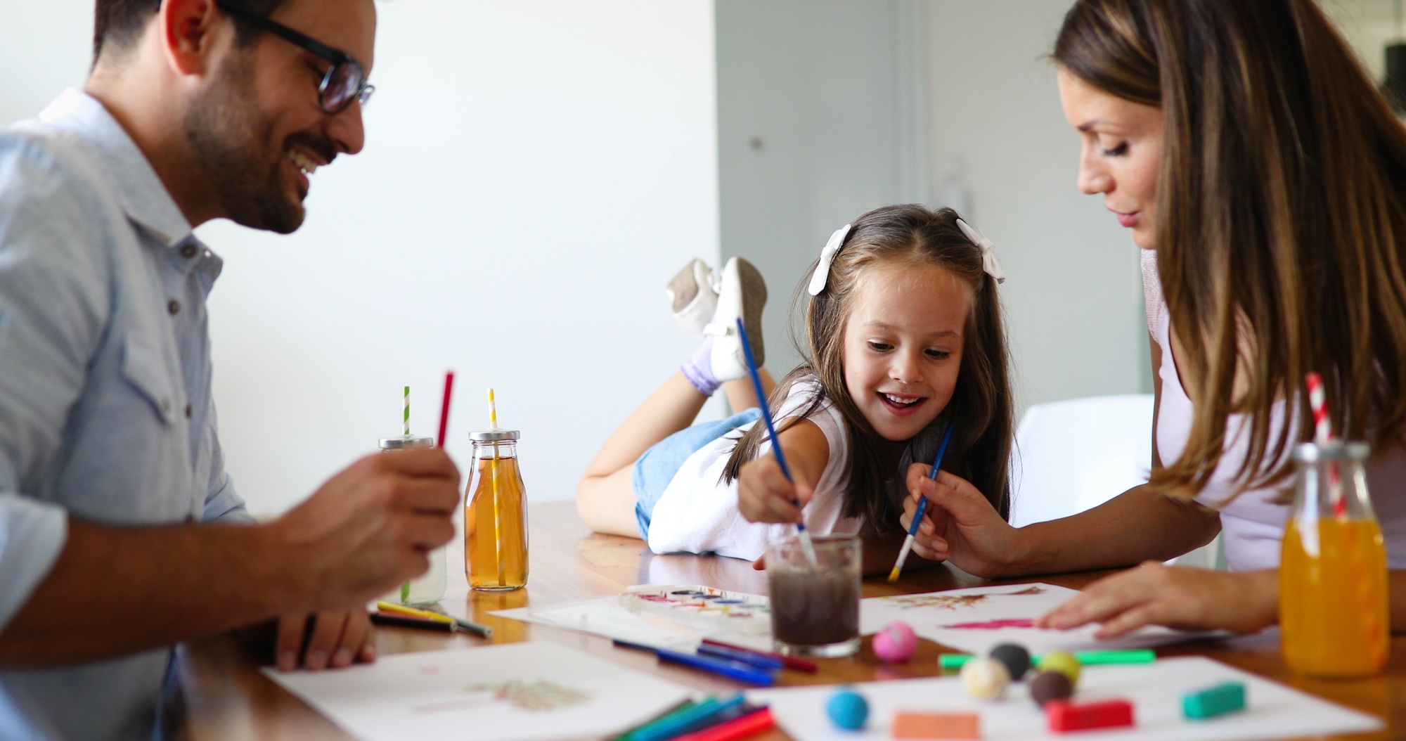 Mom and dad drawing with their daughter
