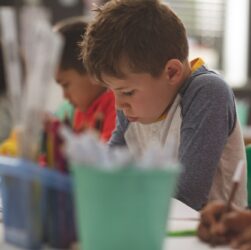 School boy writing a dictation on a notebook in a classroom