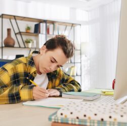 Teenger writing in notebook