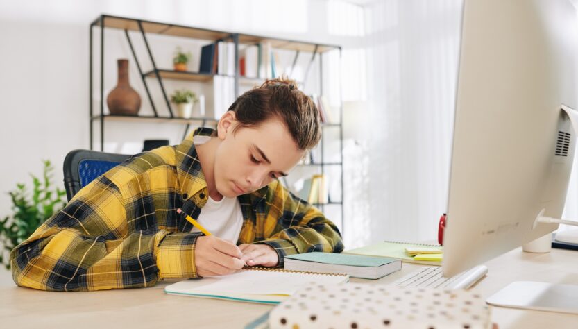 Teenger writing in notebook