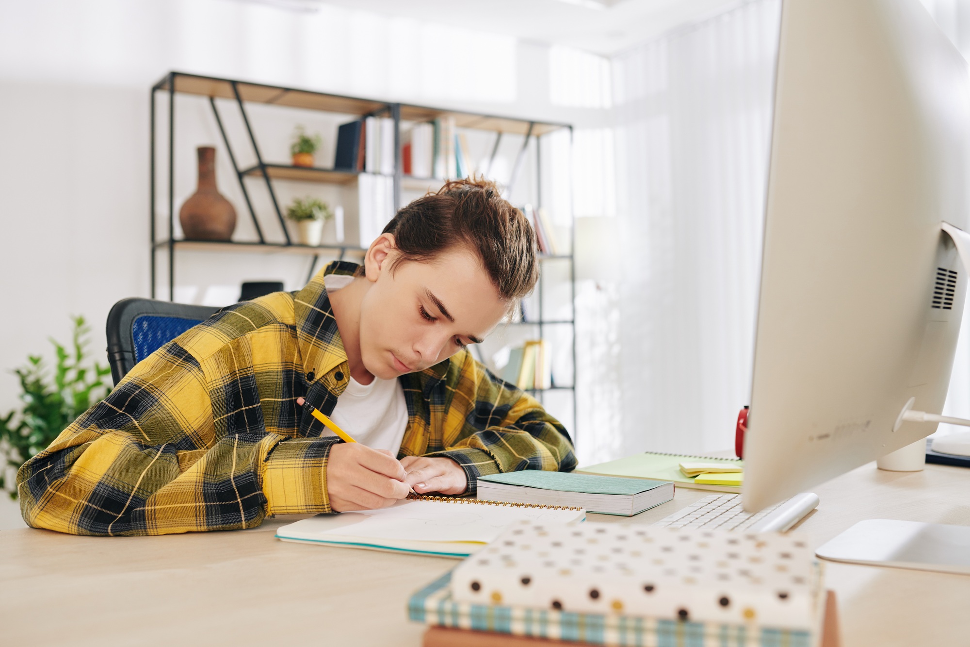 Teenger writing in notebook
